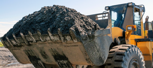 A large excavator carrying soil in it's bucket