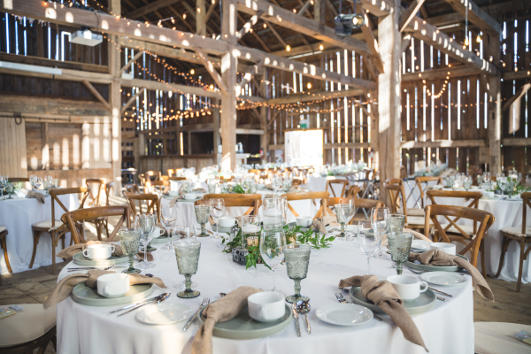 A wedding venue set up inside of a large barn
